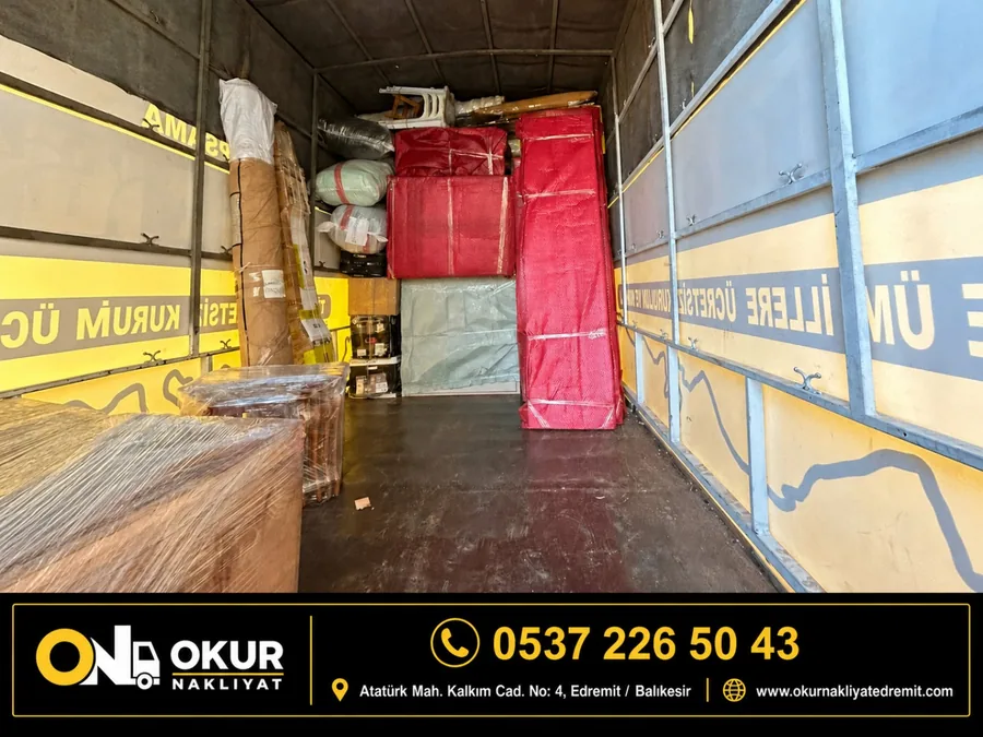 Okur Nakliyat aracının içinde koruyucu battaniye ve streçle sarılmış mobilyalar düzenli biçimde yerleştirilmiş